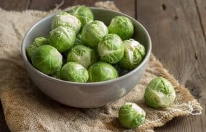 Brussels sprouts in a bowl on an old wooden table