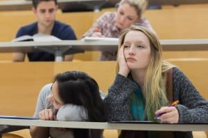 woman sitting in class hall being bored