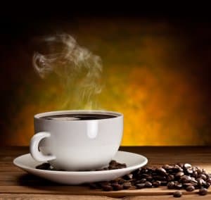 Cup of coffee with coffee beans on a beautiful brown background.