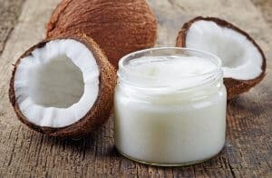 coconut oil and fresh coconuts on old wooden table