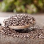 Black chia seeds on a wooden spoon