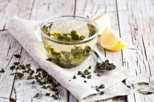 cup of green tea and lemon on rustic wooden table