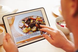 Person At Breakfast Looking At Recipe App On Digital Tablet