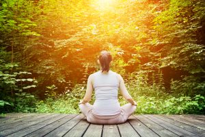 Young woman meditating in a forest. Zen, meditation, healthy breathing