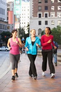 Group Of Women Power Walking On Urban Street