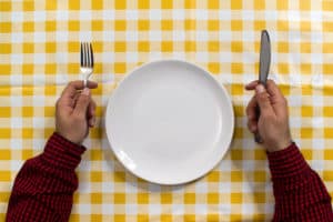 sitting at dinner table with fork